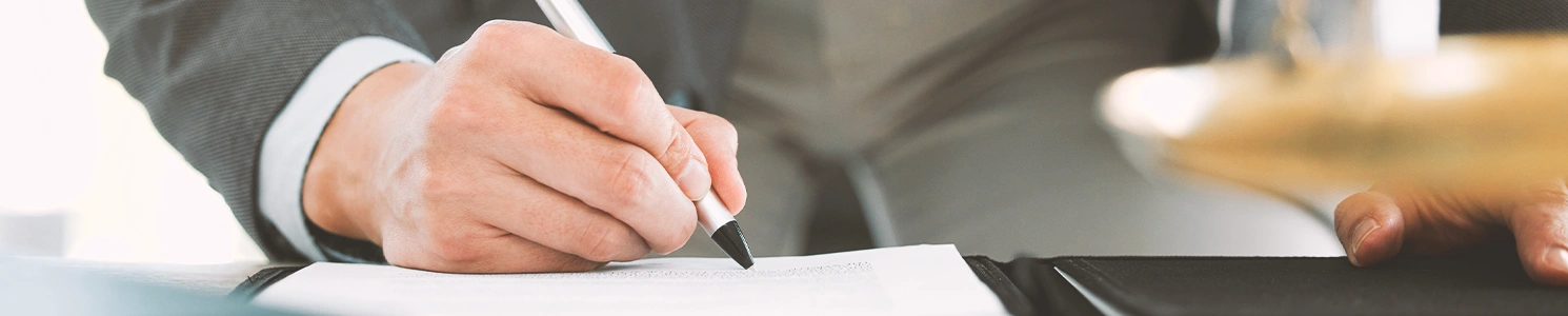 A person doing writing on paper with a pen