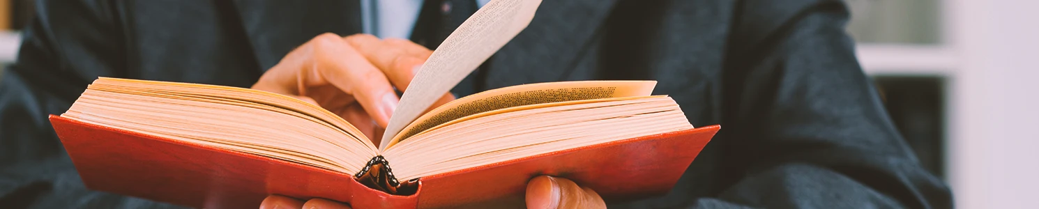 A lawyer looking into warrants in a law book