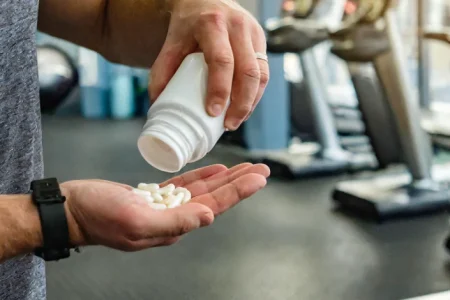 A man pouring Alpha Amino Xtreme supplement on his hand