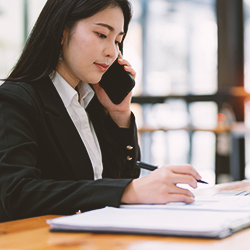 A business woman writing down notes while on the phone