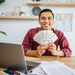A smiling employee holding his non-discretionary bonus