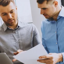 Two coworkers discussing paperwork