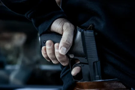 A man holding his gun from behind
