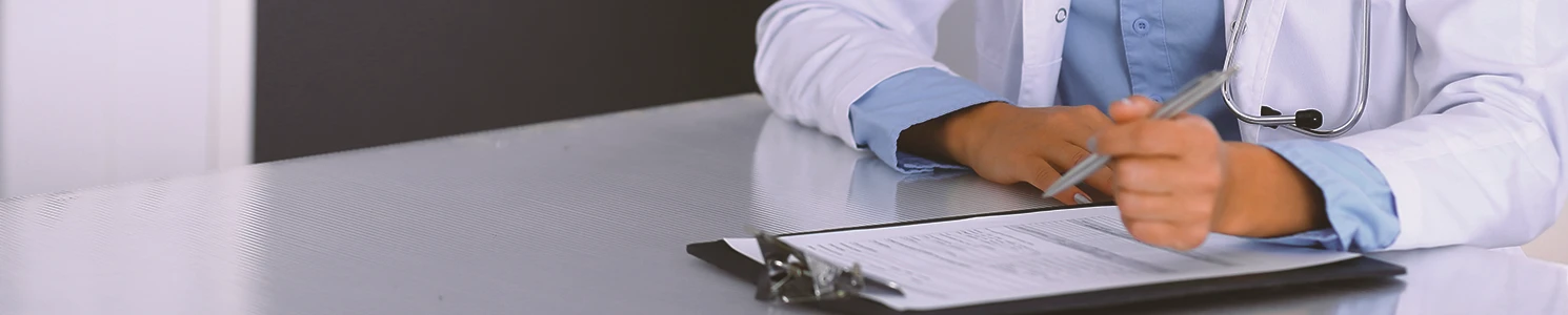 A doctor writing down common health problems from camp lejeune on a clipboard
