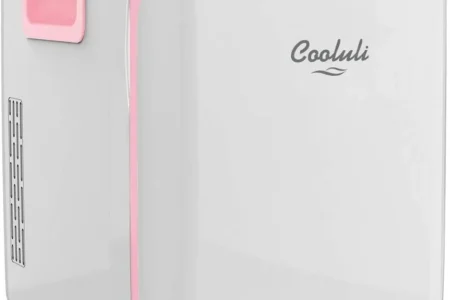 Cooluli white-and-pink mini fridge displayed on a countertop against a soft pink background.