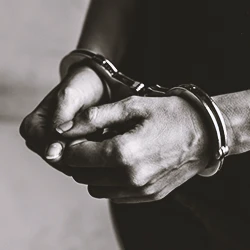 A close up shot of a criminal in handcuffs