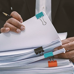 A person going through stacks of paperwork