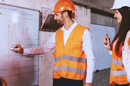 Workers discussing at a whiteboard