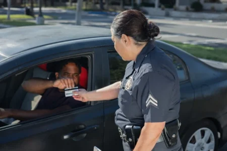 A police woman checking the driver's license of the man