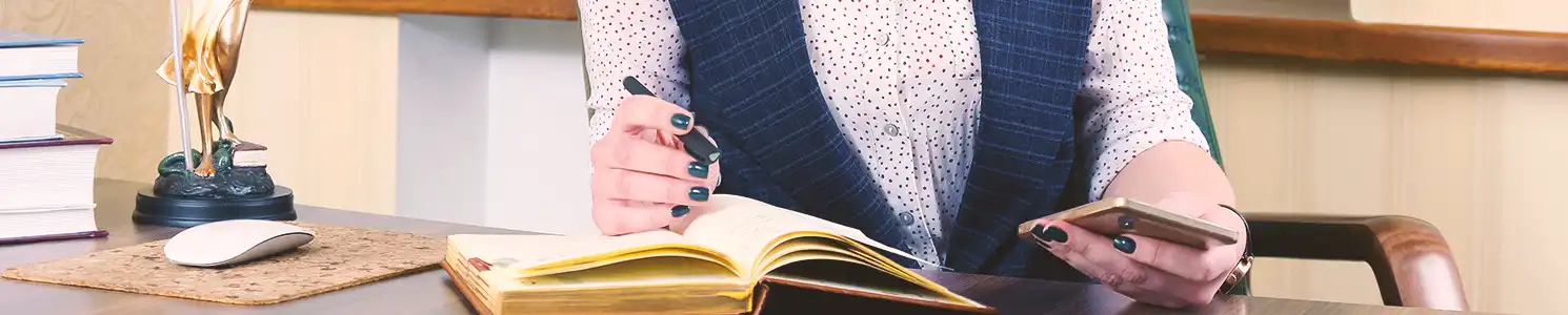 A lawyer reading a book with a pen in hand