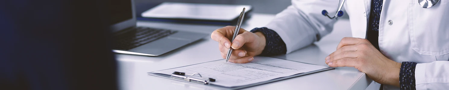 A doctor writing down health conditions eligible for the camp lejeune lawsuit