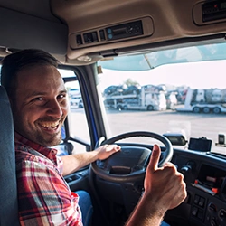 Box truck driver giving a thumbs up while driving 