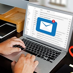 A person writing an email using a laptop