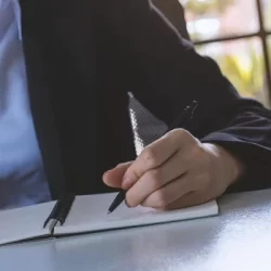 A lawyer writing down on a notebook