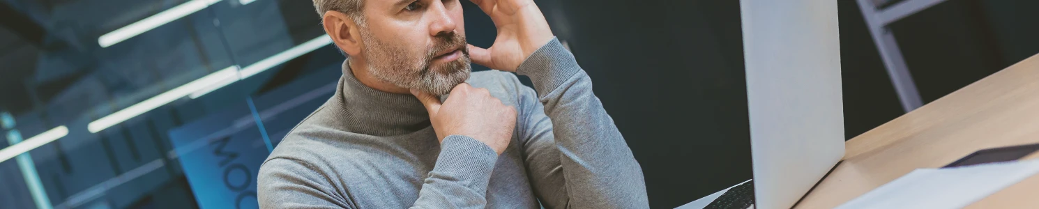A business person looking at a laptop concerned