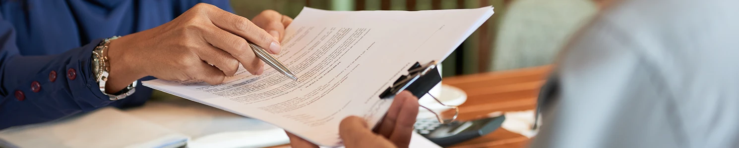 A lawyer talking with another person while pointing at a paperwork