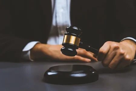 A lawyer teaching defensed against false accusations while holding a gavel