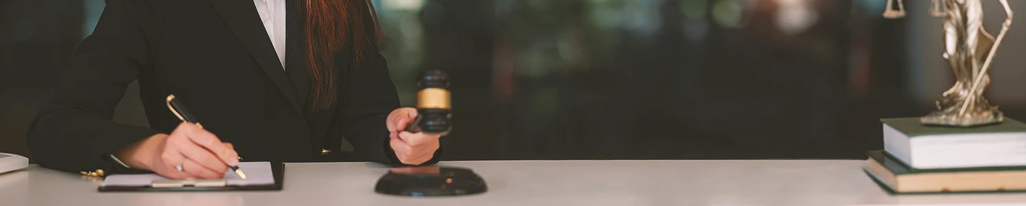 A lawyer holding a gavel and writing down notes
