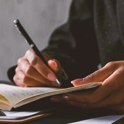 A person writing on paperwork