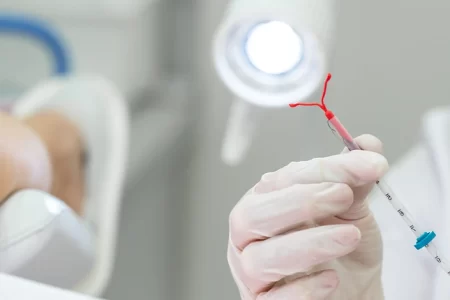 A doctor holding a IUD