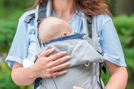 A mom carrying her baby using Infantino Baby Carrier