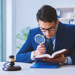 A lawyer reading a law book with a magnifying glass