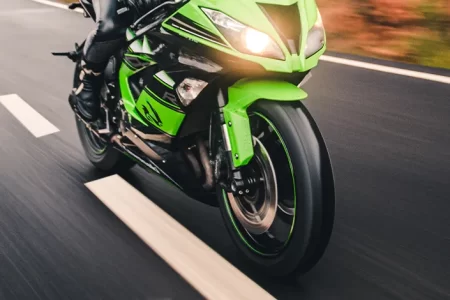 man on the kawasaki ninja bike on open road next to line on the road