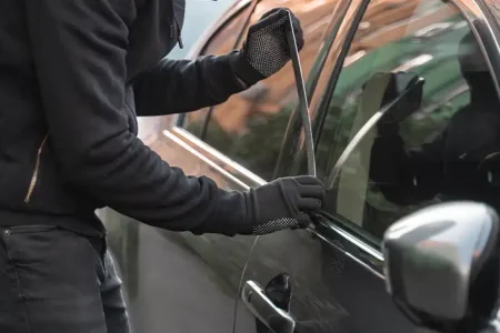 A photo of a person trying to rob a car