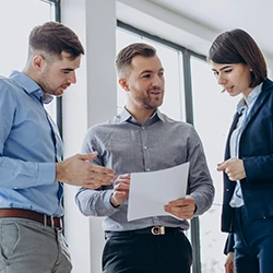 A group of people having a conversation while looking at a paperwork