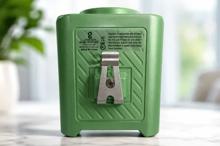 Back of a green Living Glow portable waist fan showing its metal belt clip and product label.