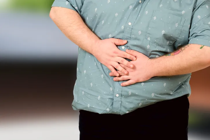 Man holding sore tummy