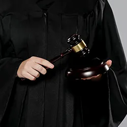 A judge standing holding a gavel 