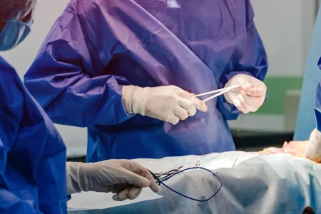 doctors operating on a patient lying in bed