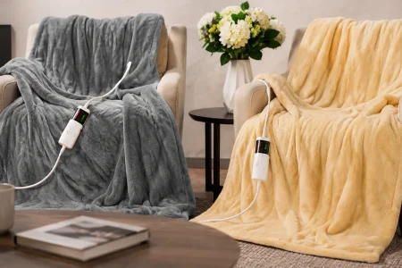 Gray and yellow OCTROT heated Sherpa blankets with wired controllers displayed on armchairs in a living room.