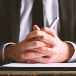 A person crossing fingers while on a table