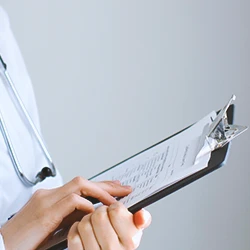 A doctor looking at a clipboard with the reasons for recall of glyphosate