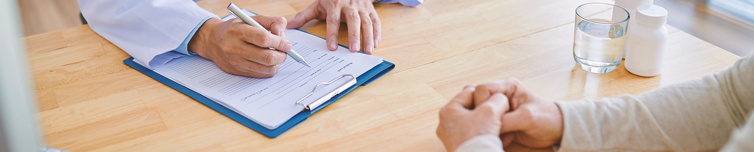A doctor writing something down in front of someone