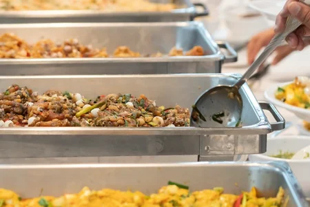 a man choosing food dish from buffet