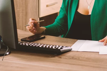 A lawyer doing paperwork while on the computer