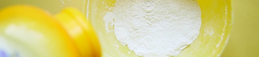 A top view of a talcum powder being poured on a bowl