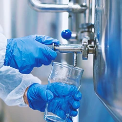 A chemist in a water treatment plan getting water