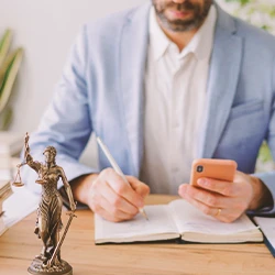 A lawyer writing down on a book while holding a phone