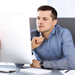 An image of a professional thinking in front of a computer