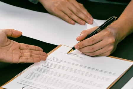 A person signing insurance claim papers