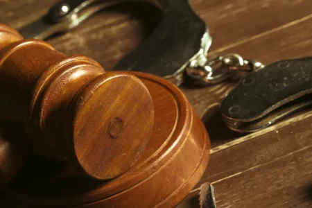 Gavel and handcuffs on wooden surface