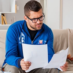 A man reading important documents on the couch