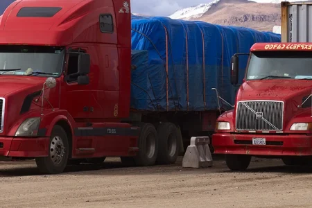 Two red Volvo Trucks on the road
