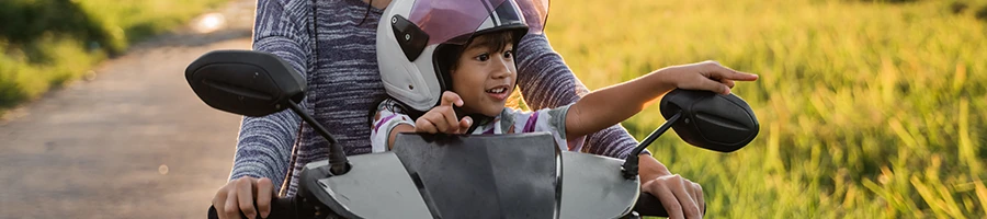 A father and his child riding a motorcycle together