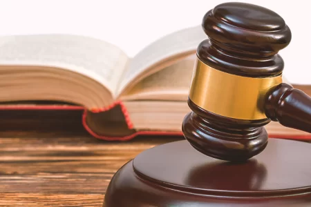 A gavel and a large book in the background