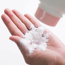 Woman pouring talcum powder on her palm 